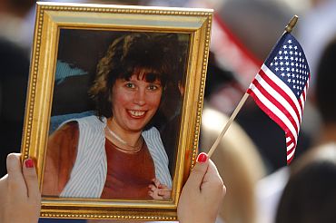 Person holds picture remembering victim of 9/11 attacks on World Trade Center during ceremonies marking 10th anniversary of attacks in New York
