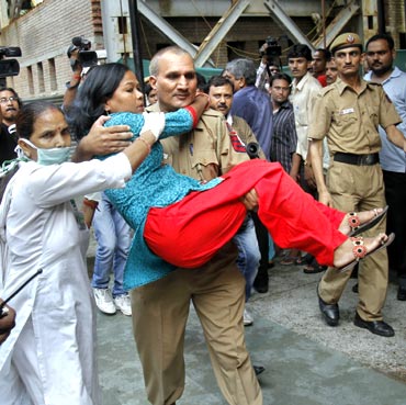 A policeman carries a woman, injured in the blast outside the Delhi high court, on September 7
