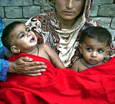 Twin boys in the arms of their mother who were born at a flood relief camp in Muzaffargarh district