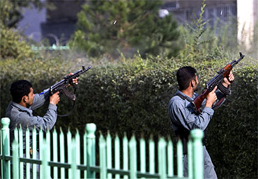 Afghan policemen fire at Taliban insurgents during an attack near the US embassy in Kabul