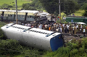Railway officials and police work at the scene of a train collision between a passenger train and a stationary train in Arakkonam, in Chennai