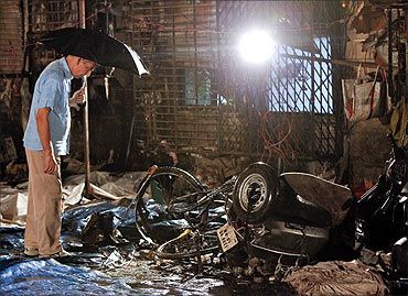 An investigator surveys the site of a blast in Zaveri Bazaar Mumbai
