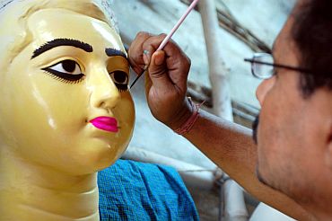 Artist Indrajit Paul of Kumartuli giving the final touches to an idol