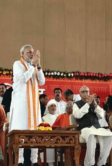 Modi greets his supporters while Advani looks on