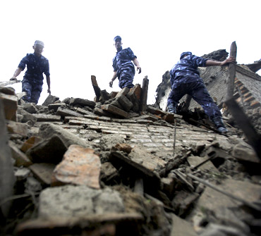 Nepalese police search for casualties in the ruins of a quake-damaged house at Lokanthali in Bhaktapur