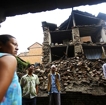 Residents survey damaged buildings a day after a magnitude 6.8 earthquake struck Nepal, India and Bangladesh, at Bhaktapur in Nepal