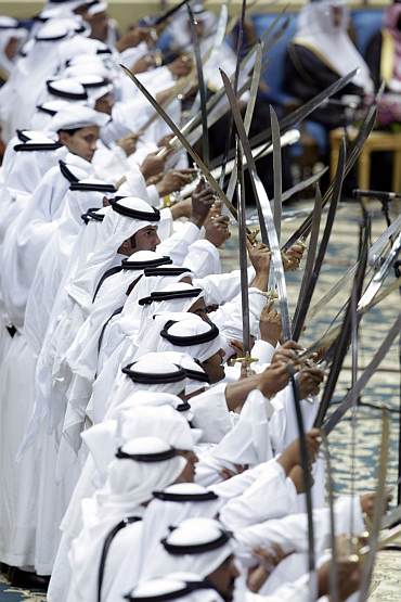 Saudis raise their swords during a traditional dance performance