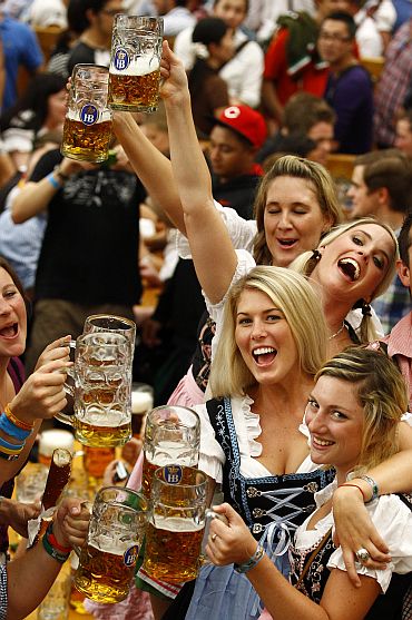 Revellers toast with the traditional 1-litre beer mugs at the opening of the Munich Oktoberfest