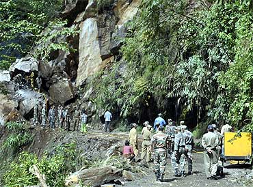 Army personnel work to clear a road blocked by landslide, which was caused by Sunday's earthquake, at Mangan village