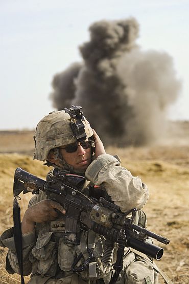 A US soldier takes cover from shelling