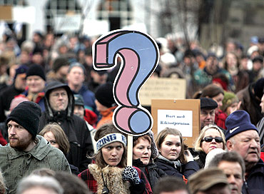 A woman holds a placard during a peaceful protest near Iceland's Parliament house in Reykjavik