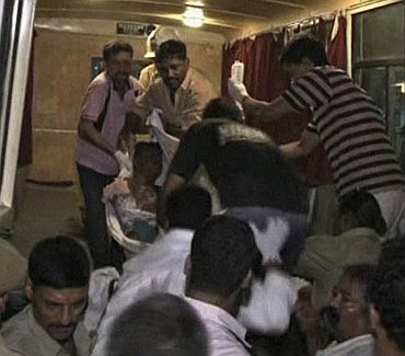 A victim is rushed to an ambulance after explosions in Mumbai in this still image taken from video