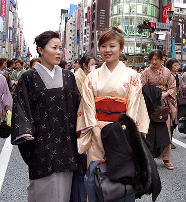 Kimono-clad women walk across a street during an event at Tokyo's Ginza shopping district