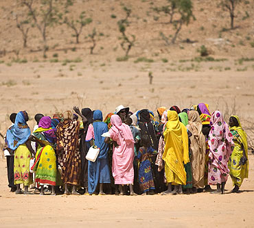 Women who fled fighting in eastern Chad gather around members of a delegation from the UNSC