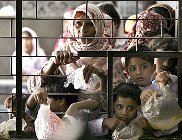 Women and children wait for free food at the shrine of Muslim Saint Data Ganj Bakhsh in Lahore