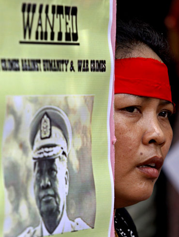 A woman holds a placard during a protest against Myanmar's military ruler Than Shwe