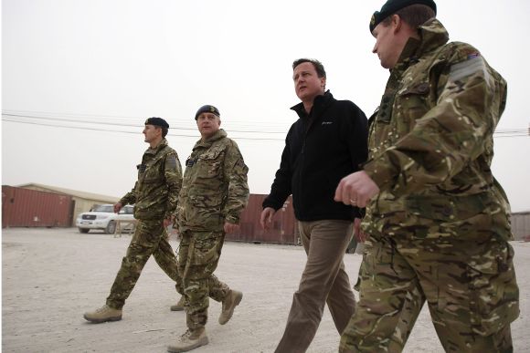 Britain's Prime Minister David Cameron walks through Kandahar airfield during a visit to meet British forces in Afghanistan