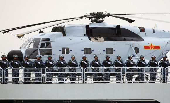 Chinese marines aboard a naval ship with a Changhe Z-8 helicopter during a ceremony in Qingdao