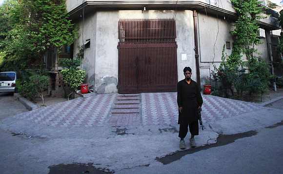 A private security guard stands outside the residence of Saeed
