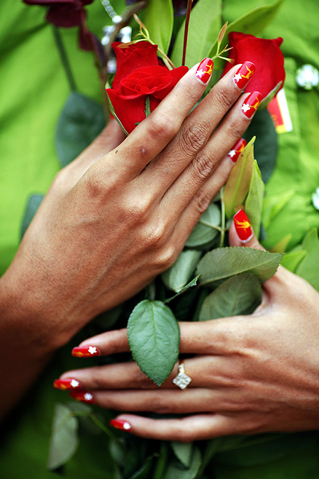 A supporter with nails painted in the NLD's colours holds flowers for Aung San Suu Kyi.