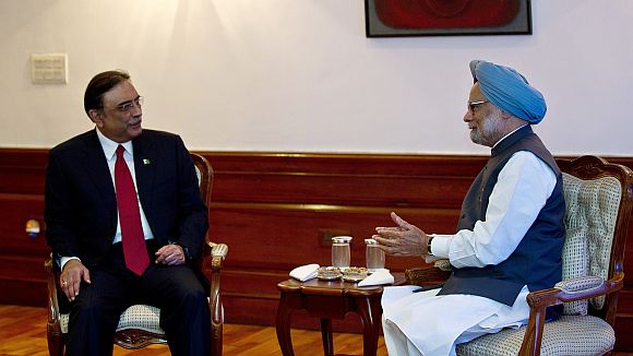 Prime Minister Manmohan Singh gestures while speaking with Pakistan President Asif Ali Zardari during a meeting in New Delhi
