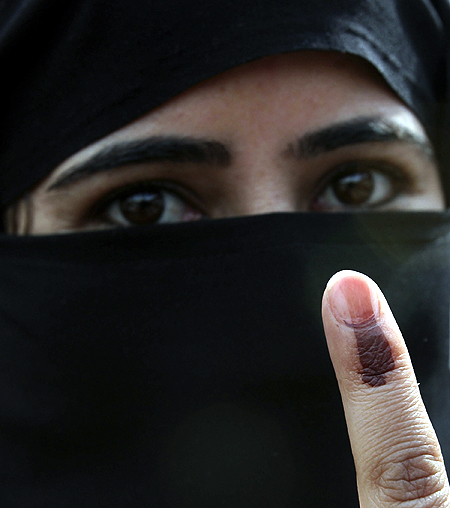 A voter displays her finger after casting her ballot in Kashmir.