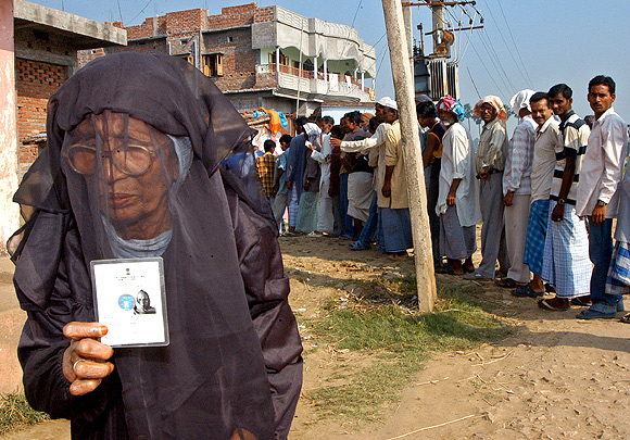A Muslim woman holds up her voter's identity card in Patna
