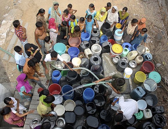 Residents fill their containers with drinking water from a water tanker provided by the Rajasthan government in Jaipur