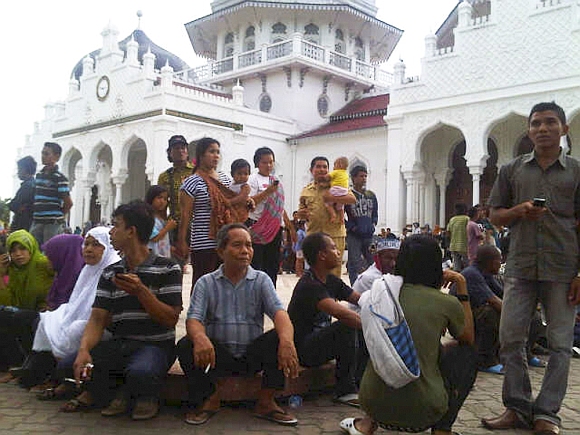 People gather outside the Baiturrahman mosque after the quake