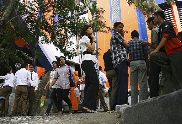 Office workers evacuate and gather in front an office building in Medan after the quake