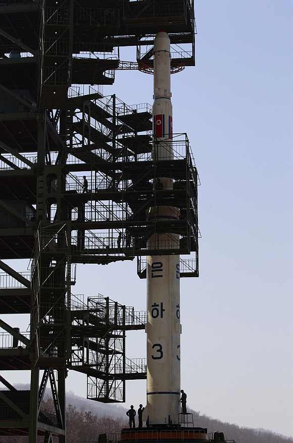 Engineers are seen checking the Unha-3 rocket sitting on a launch pad at the West Sea Satellite Launch Site, during a guided media tour by North Korean authorities in the northwest of Pyongyang