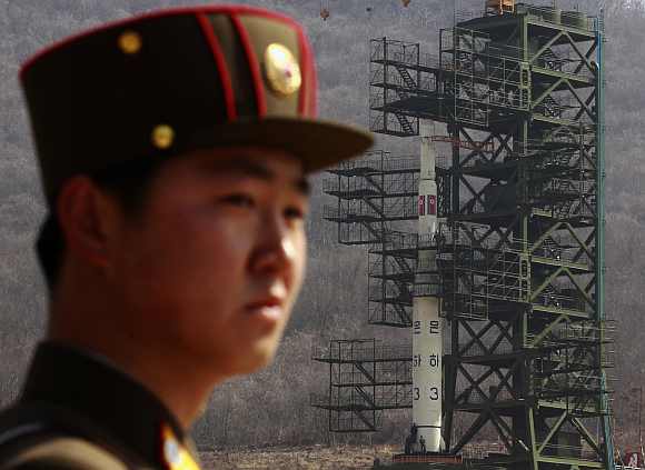 A soldier stands guard in front of the rocket sitting on a launch pad at the West Sea Satellite Launch Site, during a guided media tour by North Korean authorities in the northwest of Pyongyang