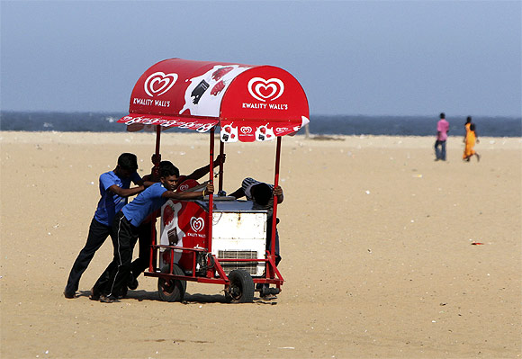 People move an ice-cream cart from the Marina beach after a tsunami alert was issued in Chennai