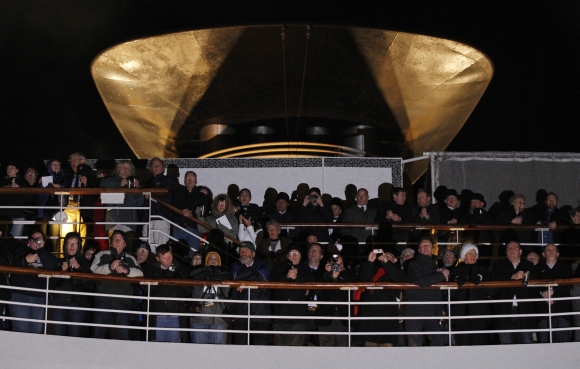 Passengers stand on upper decks and view a service of remembrance aboard the Titanic Memorial Cruise
