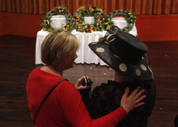 Helena Beaumont-Jones of Airlie Beach, Australia is embraced by Titanic Memorial Cruise general manager Tara Plumley while viewing three wreaths before a memorial service on board