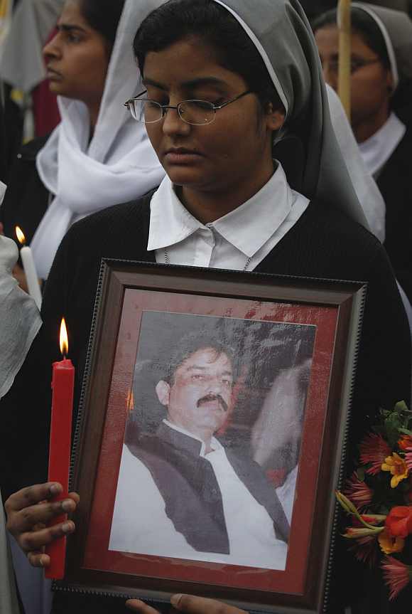 A Christian holds a picture of slain Minister for Minorities Shahbaz Bhatti during a candlelight vigil in Lahore March 12, 2011. Bhatti, the country's only Christian government minister, was killed on March 2 for challenging a law that stipulates death for insulting Islam