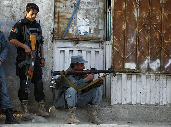 Afghan policemen take position at the site of an attack in Kabul