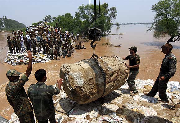 Soldiers repair the Sutlej Yamuna Link Canal after it was damaged by heavy rain in Kurukshetra, Haryana