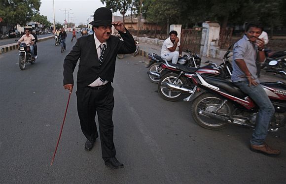 Ashok Aswani, in costume as Charlie Chaplin walks on a road in Adipur