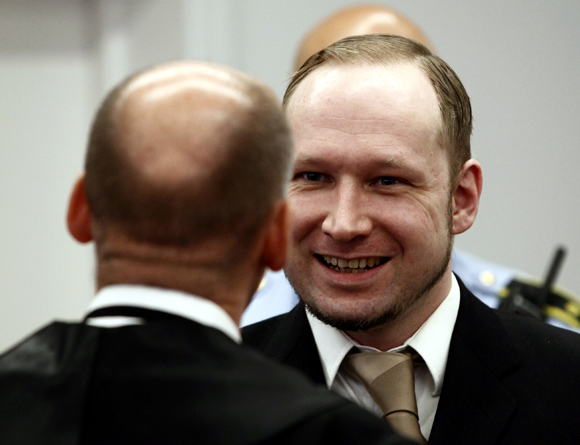 Defendant Anders Behring Breivik discusses with his defence lawyer Geir Lippestad in the courthouse in Oslo