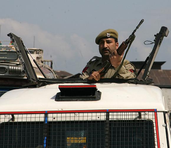 A policeman keeps a close watch at the site where an ASI was shot by militants