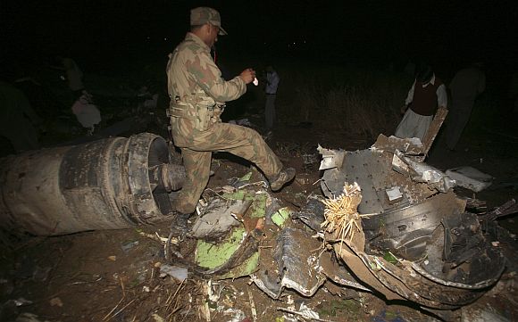 An army soldier walks through the wreckage of the Boeing 737 airliner which crashed in Islamabad
