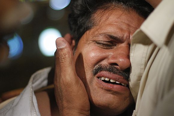 A relative of a victim of the Bhoja Air airliner crash mourns at the Jinnah International Airport in Karachi
