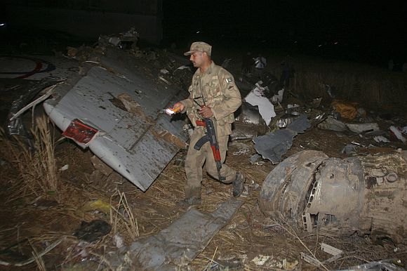 An army soldier walks through the wreckage of the Boeing 737 airliner