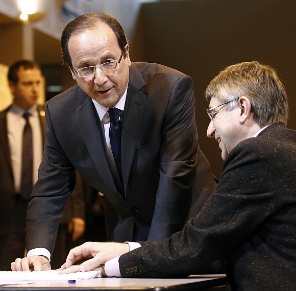 Francois Hollande signs the electoral register after casting his ballot in the first round of 2012 French presidential election at a polling station in Tulle