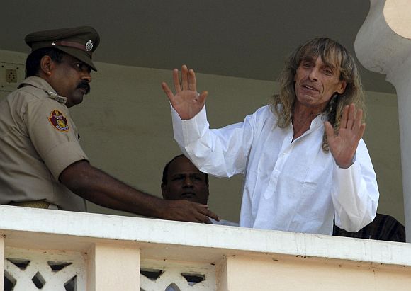 Freed Italian tour guide Paolo Bosusco, who was taken hostage by Maoist rebels, waves from a balcony of a guest house in Bhubaneswar