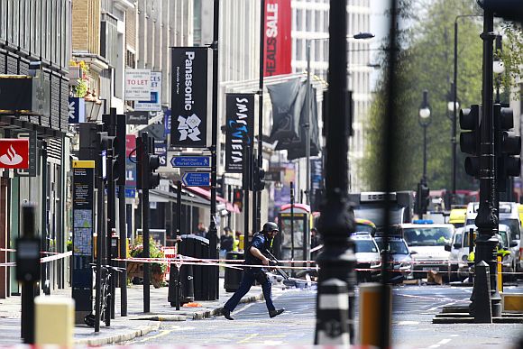 An armed police officer runs in Tottenham Court Road in central London during the hostage crisis