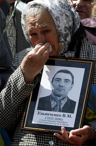 A woman holds a portrait of a victim of the Chernobyl nuclear disaster during a ceremony in Kiev