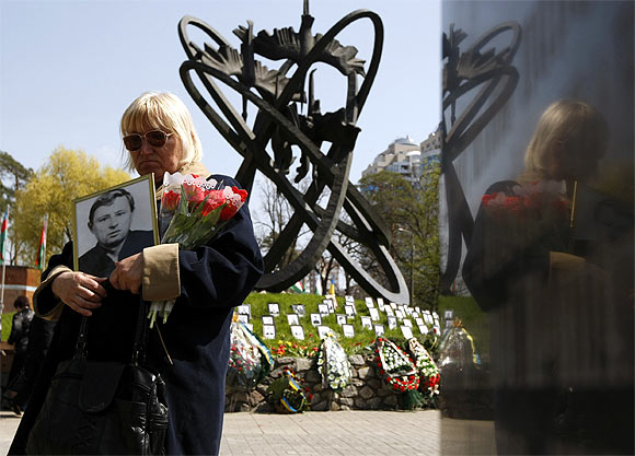 A woman holds a portrait of a victim of the Chernobyl nuclear disaster during a ceremony in Kiev