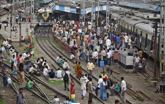 Passengers crowd at a railway station as they sit on tracks while waiting for the electricity to be restored in Kolkata on Wednesday